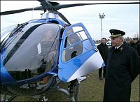 ministr za ovládacími pákami v kokpitu nového policejního vrtulníku. 