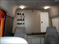 Vnitřní část vozu (proti směru jízdy) - pracovní plocha s analogovými radiostanicemi – Mercedes Spri