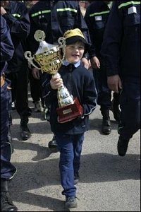 Nejmladší účastník závodů Vašek Sirůček nese putovní pohár na slavnostní nástup