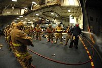 cvičení hasičů v hangáru letadlové lodi